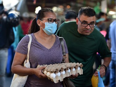 A woman wears a protective face mask to prevent the spread of the new Coronavirus, at the Agriculture Market, in Tegucigalpa, on March 14, 2020. - Honduran government has prohibited citizens from Europe, China, Iran, and South Korea the entrance to the country.