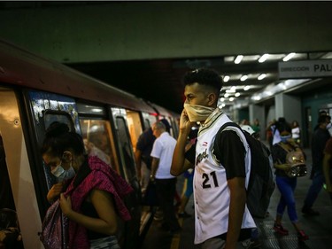 People travel on the subway wearing protective masks as a preventive measure in the face of the global COVID-19 coronavirus pandemic, in Caracas, on March 14, 2020.