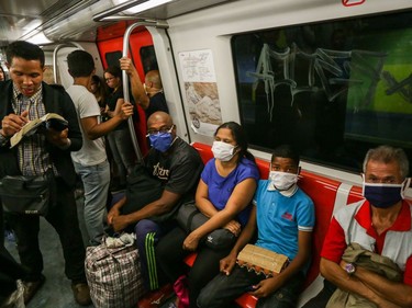 People travel on the subway wearing protective masks as a preventive measure in the face of the global COVID-19 coronavirus pandemic, in Caracas, on March 14, 2020.