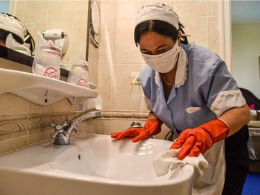 An employee of the Cuban National Hotel cleans and disinfect the bathroom of a room occupied by tourists, as a preventive measure in the face of the global COVID-19 coronavirus pandemic, in Havana on March 14, 2020.