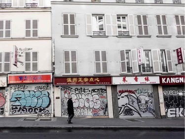A man walks past closed shops in Paris on March 15, 2020, a day after France ordered the closure of all non-essential public places including restaurants and cafes, amid the COVID-19 outbreak, caused by the novel coronavirus. - France will progressively reduce long-distance train, bus and plane travel over the coming days in a bid to limit the spread of the coronavirus, the government announced on March 15. The country has already shuttered cafes, restaurants, schools and universities and urged people to limit their movements.