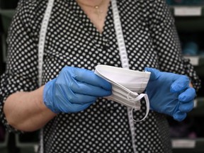 Head of the Miroglio Atelier, Graziella Baldino checks a mask at the Atelier Miroglio masks factory on March 17, 2020 in Alba, near Cuneo, Northwestern Italy. - Miroglio is a tissues factory that started to produce masks not for sanitary use after the COVID-19 coronavirus emergency. The masks are made of cotton with a waterproof treatment.