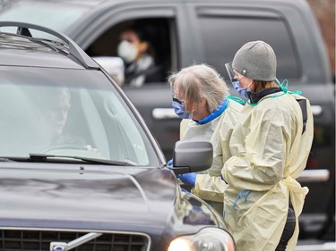 Health care workers speak with patients at a drive-thru Covid-19 assessment center in London, Ontario, on March 17, 2020.