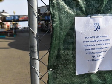 A sign is posted on a fence announcing the closure of Pier 39 and Fisherman's Wharf in San Francisco, California.