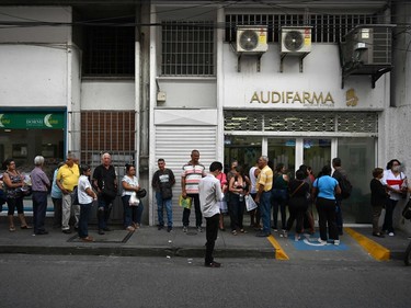 People line up to buy medicines outside a pharmacy in Buga, Valle del Cauca, Colombia. Quarantines and closing borders, schools and shops, are the main measures being taken in many countries araound the world to fight the spread of the novel coronavirus.