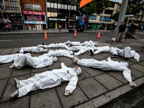 Youngsters wearing protective suites take part in a performance as part of an awareness campaign against the spread of the new coronavirus, COVID-19, in Bogota on March 18, 2020.
