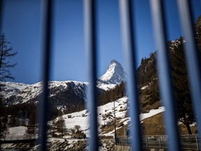 This photograph taken on March 18, 2020, shows a view behind railings in the Alpine resort of Zermatt, of the Matterhorn mountain, amid the spread of the COVID-19 caused by the novel coronavirus. - The Swiss government on March 16, 2020, declared a state of emergency lasting until April 19 in a bid to combat the coronavirus pandemic. All shops, restaurants, bars, entertainment and leisure facilities had to shut down, with the exception of grocery stores, pharmacies and health facilities.
