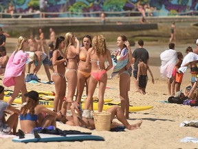 Crowds are seen on Bondi Beach ahead of its closure in Sydney on March 21, 2020. - Authorities temporarily closed Bondi Beach on March 21, after huge crowds flocked to the iconic surfing spot despite government orders not to congregate due to the coronavirus pandemic.