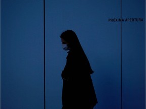 A woman wearing a face mask walks in Barcelona on March 21, 2020 during a national lockdown to prevent the spread of the new coronavirus. - Spain reported a 32 percent spike in new deaths from the coronavirus, bringing the country total to 1,326 fatalities, the second highest in Europe after Italy. Spain has issued lockdown orders for some 46 million people who are only permitted to leave their homes for essential work, food shopping, medical reasons or to walk the dog.