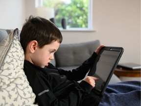 A six-year-old navigates online learning resources in the family room in northern England. In countries around the world, school is shut down.
