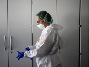 A nurse puts on her Personal Protective Equipment (PPE) before starting to work on the preparation of the Intensive care unit in the new Covid-19 Hospital on March 29, 2020 in Verduno, near Alba, Northwestern Italy.