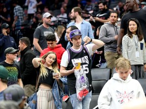 Fans react after it was announced that the game between the New Orleans Pelicans and the Sacramento Kings was postponed at the Golden 1 Center.