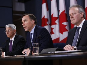 Bill Morneau, minister of finance, centre, speaks while Stephen Poloz, governor of the Bank of Canada, right, and Jeremy Rudin, head of the Office of the Superintendent of Financial Institutions, listen during a news conference in Ottawa on Friday.