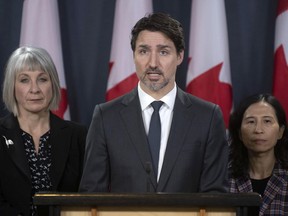 Federal Minister of Health Patty Hajdu and Chief Medical Officer Theresa Tam (right) look on as Prime Minister Justin Trudeau speaks during a news conference. On Thursday, the prime minister isolated himself as his spouse awaited the results of a coronavirus test.