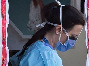 A hospital worker wearing a face shield and mask is seen at a COVID-19 assessment centre for staff at Lions Gate Hospital, in North Vancouver, on Thursday, March 19, 2020. According to Vancouver Coastal Health three administrative staff members at the hospital tested positive for the virus last week.
