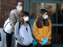 People wear masks and stand apart from each other as they wait to enter a supermarket in Santa Monica, California.