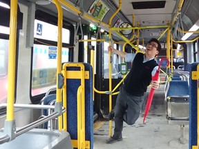 OC Transpo operator Wilson 'Wash your hands' does his best Gene Kelly Singing in the Rain imitation, Thursday, Mar. 26. Wilson assured everyone the pole was sanitized before and after his routine.