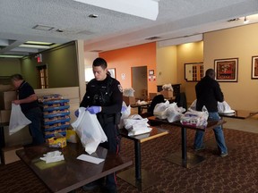 Ottawa police neighbour officers help the Caldwell Family Centre staff fill food hampers and hand them out.