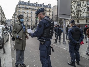 Police officers question a man walking in public after a government enforced quarantine on March 17, 2020 in Paris, France. On March 17, 2020 France imposed a nationwide lockdown to control the spread of COVID-19.