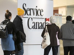 People line up at a Service Canada office in Montreal on Thursday, March 19, 2020.