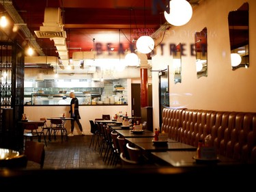 A  worker stands in an empty restaurant in London, Britain, as the number of coronavirus (COVID-19) cases grow around the world.