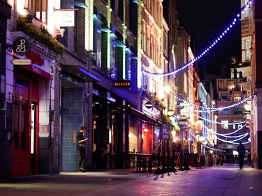 A worker smokes a cigarette outside of a restuarant in London, England, as the number of coronavirus (COVID-19) cases grow around the world.