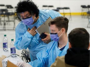 Medical staff members assess someone portraying the role of a patient as they prepare to receive people for coronavirus screening at a temporary assessment center at the Brewer hockey arena in Ottawa, Ontario, Canada March 13, 2020.  REUTERS/Patrick Doyle ORG XMIT: GGG-OTW108