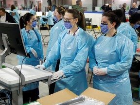 Medical staff members prepare to receive patients for coronavirus screening at a temporary assessment centre at the Brewer hockey arena in Ottawa, Ontario.