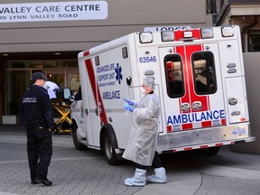 A paramedic (R) speaks with a firefighter (L) outside the Lynn Valley Care Centre, a seniors care home which housed a man who was the first in Canada to die after contracting novel coronavirus, in North Vancouver, British Columbia, Canada March 9, 2020.