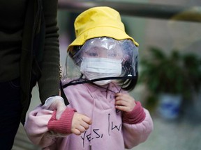 A child wearing a face mask and a face shield is seen at a railway station in Xianning of Hubei province, the epicentre of China's coronavirus disease (COVID-19) outbreak, March 25, 2020.