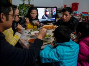 The Cai family are seen at dinner, as a TV broadcasts news on the coronavirus in the living room of their home in Shanghai, China, as the country is hit by an outbreak of a new coronavirus, February 20, 2020. Picture taken February 20, 2020.