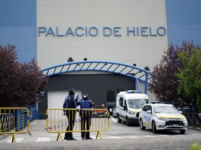 Local police stand guard outside an ice rink, which will be used as a morgue, during the coronavirus disease (COVID-19) outbreak in Madrid, Spain, March 24, 2020.