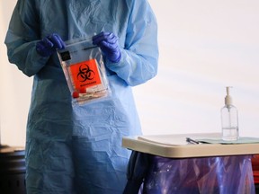 A nurse holds a completed test with patient samples at a drive-through testing site for coronavirus, flu and RSV, currently by appointment for employees at UW Medical Center Northwest in Seattle, Washington, U.S. March 9, 2020.