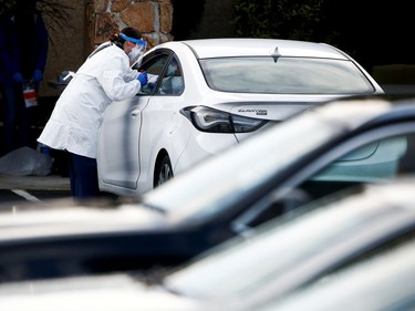 A nurse administers a nasal swab through a car window outside Life Care Center of Kirkland, a long-term care facility linked to several confirmed coronavirus cases, in Kirkland, Washington, U.S. March 14, 2020.