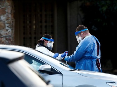 A nurse in protective gear transfers nasal swab samples to a biohazard storage bag at Life Care Center of Kirkland, a long-term care facility linked to several confirmed coronavirus cases, in Kirkland, Washington, U.S. March 14, 2020.