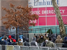 People wait in line to be tested for coronavirus disease (COVID-19) while wearing protective gear, outside Elmhurst Hospital Center in the Queens borough of New York City, U.S., March 25, 2020.
