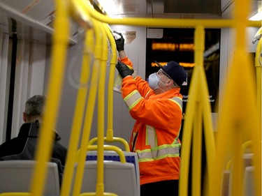A worker cleans on the LRT heading west during rush hour  in Ottawa Thursday March 19, 2020.