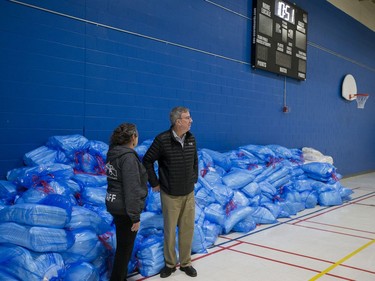 Mayor Jim Watson gets a look at the stacks of fresh linens as he tours the isolation centre for vulnerable residents ahead of its opening on Monday, with Wendy Muckle, executive director of Ottawa Inner City Health, and members of the Human Needs Taskforce.