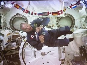 Canadian Space Agency astronaut David Saint-Jacques turns sideways during his last press conference in orbit before returning to Earth on June 24, seen on a giant screen in Saint-Hubert, Que. on Wednesday, June 19, 2019. In Saint-Jacques' line of work, physical distancing comes with the job. The Canadian astronaut spent 204 days aboard the International Space Station, returning last June after nearly seven months working alongside a small crew aboard the International Space Station, far from his family.THE CANADIAN PRESS/Paul Chiasson