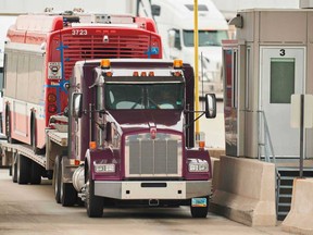 A trucker waits at the Canada Customs booth in Sarnia, Ontario. The border to the U.S. has been closed to all but essential travel.