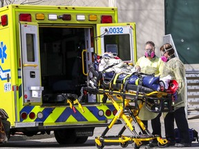 Paramedics wheel a resident out of Résidence Herron in Dorval on Wednesday, April 8, 2020.