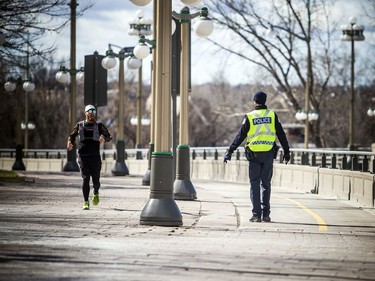 OTTAWA -- April 11, 2020 -- Gatineau police were on the Portage Bridge policing vehicle and pedestrian traffic using the bridge, Saturday, April 11, 2020. They turned this runner around, sending him back to the Ontario side.