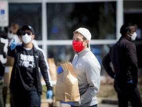 St. John Ambulance and volunteers come together, masked, to accept public donations and supply personal protective equipment to local physicians on the weekend.
