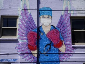 A mural depicting a medical worker with a mask covering her mouth and nose, wearing boxing gloves and angel-like wings on her back is seen on April 14, 2020 in downtown Denver, United States.
