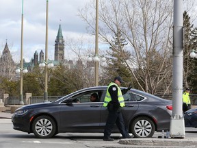 Gatineau Police officers spot-check traffic leaving from and arriving into Gatineau on the Portage Bridge on Wednesday. More than a river separates West Quebec from Ottawa now.