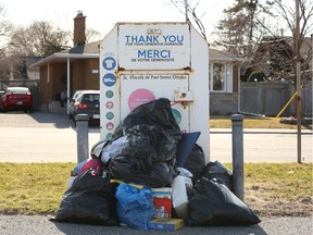 An donation bin for the now-closed St. Vincent de Paul overflows with donations that can't be collected or sorted.