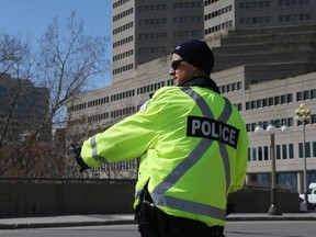 A Gatineau Police officer keeps a safe distance from a motorist on the Portage Bridge while questioning him about where he is going, April 15.
