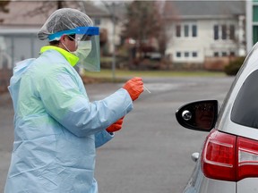 Nurses take COVID-19 swabs at drive-thru testing site outside the Almonte General Hospital.