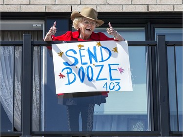 With tongue firmly planted in her cheek no doubt, Annie Pomerleau, a resident, has a laugh with the sign she made for the vehicle parade at the City View Retirement Community on Saturday. Wayne Cuddington, Postmedia