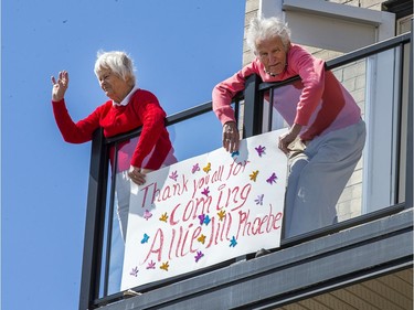 Residents wave from their balcony during the vehicle parade past the City View Retirement Community on Saturday. Wayne Cuddington, Postmedia